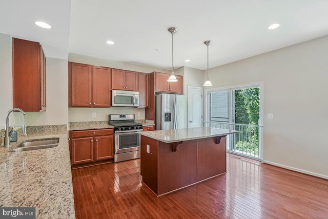 12310 Sandstone St, Waldorf, MD 20601 - kitchen featuring appliances with stainless steel finishes, dark wood-type flooring, light stone countertops, hanging light fixtures, and a center island