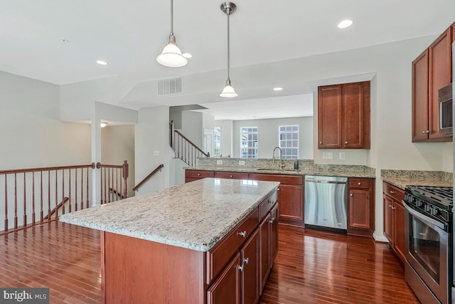 12310 Sandstone St, Waldorf, MD 20601 - kitchen featuring stainless steel appliances, dark wood-type flooring, light stone countertops, a center island, and hanging light fixtures