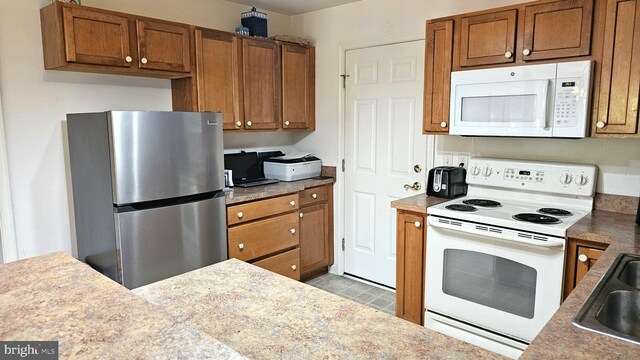 5934 Tappan Ln, Salisbury, MD 21801 - kitchen with white appliances, brown cabinets, and a sink