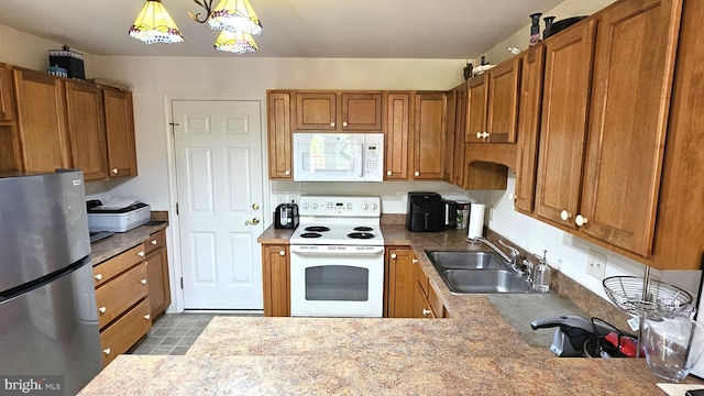 5934 Tappan Ln, Salisbury, MD 21801 - kitchen with white appliances, a sink, brown cabinets, and pendant lighting