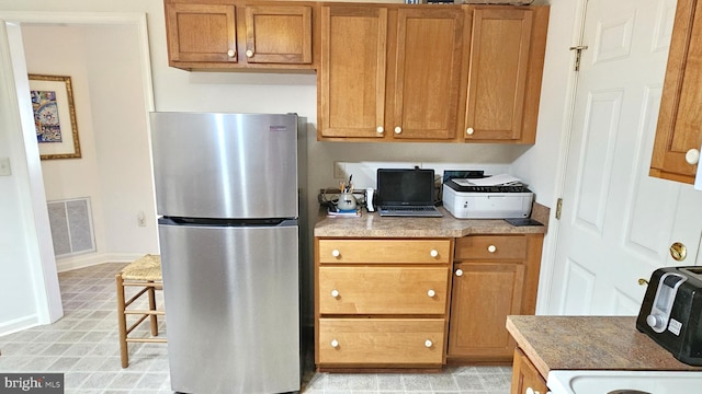 5934 Tappan Ln, Salisbury, MD 21801 - kitchen featuring freestanding refrigerator, brown cabinetry, and baseboards