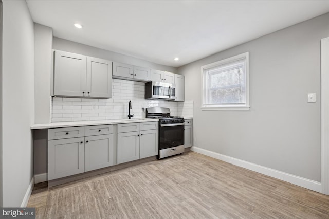 2434 N 26th St, Philadelphia, PA 19132 - kitchen featuring appliances with stainless steel finishes, a sink, tasteful backsplash, gray cabinetry, and recessed lighting