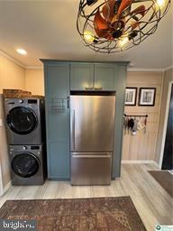 333 Decker Ferry Rd, Mount Bethel, PA 18343 - kitchen featuring fridge, stacked washer / dryer, light wood-style flooring, crown molding, and baseboards