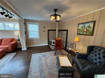 333 Decker Ferry Rd, Mount Bethel, PA 18343 - living area featuring crown molding, baseboards, a wood stove, and wood finished floors