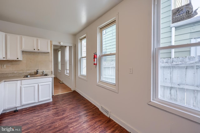 753 N 12th St, Reading, PA 19604 - kitchen with dark wood-type flooring, decorative backsplash, white cabinetry, and light countertops