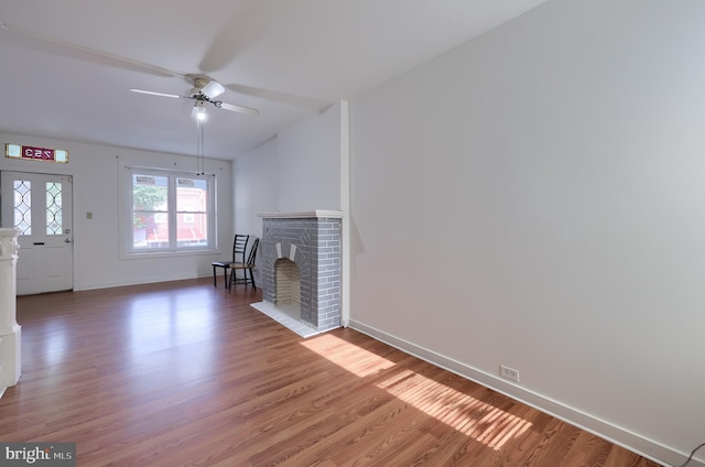 753 N 12th St, Reading, PA 19604 - unfurnished living room featuring ceiling fan, light wood-style flooring, and a fireplace