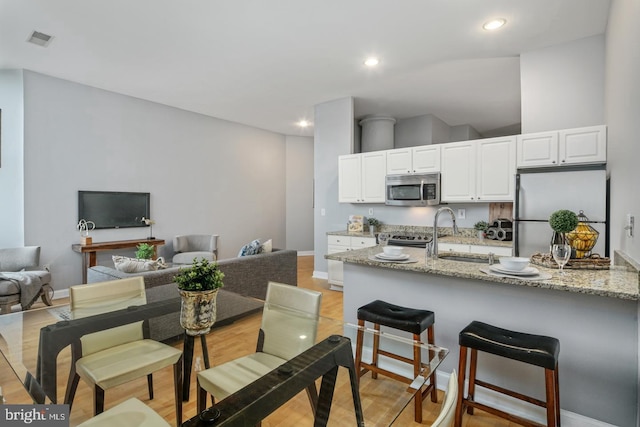 315 Arch St Unit 406, Philadelphia, PA 19106 - kitchen with appliances with stainless steel finishes, a sink, a kitchen bar, white cabinets, and recessed lighting