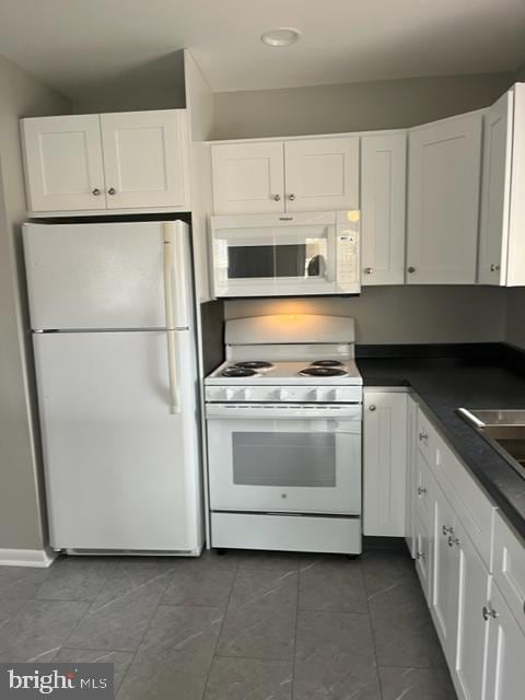 8 Florence Tollgate Pl, Florence, NJ 08518 - kitchen with white appliances, white cabinets, dark countertops, dark tile patterned flooring, and recessed lighting
