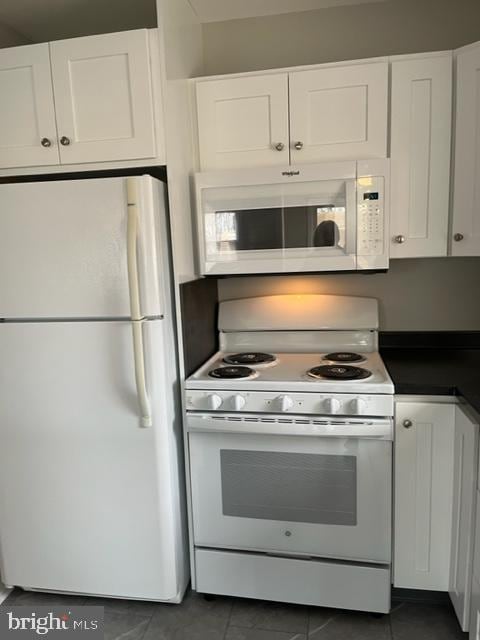 8 Florence Tollgate Pl, Florence, NJ 08518 - kitchen featuring white appliances, white cabinetry, dark countertops, and dark tile patterned flooring