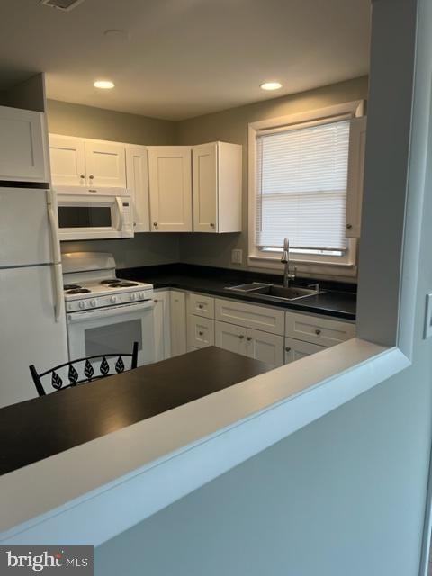 8 Florence Tollgate Pl, Florence, NJ 08518 - kitchen with white appliances, a sink, white cabinets, dark countertops, and recessed lighting