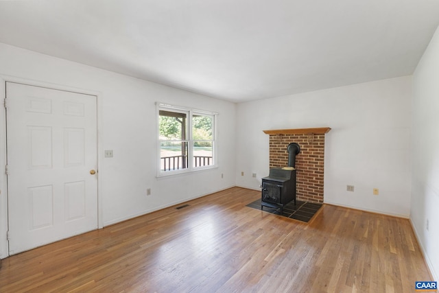 406 Green Meadow Ln, Scottsville, VA 24590 - unfurnished living room with a wood stove, wood finished floors, and baseboards