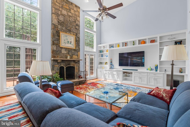 505 Sherwood Mills Ct, Sandy Spring, MD 20860 - living room featuring a towering ceiling, light wood-style floors, ceiling fan, and a fireplace