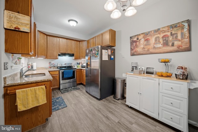 5341 Yellow Turtle Pl, Woodbridge, VA 22193 - kitchen featuring appliances with stainless steel finishes, under cabinet range hood, light stone counters, light wood-type flooring, and a chandelier