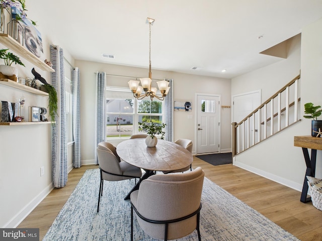 11020 Augusta Ln Unit 3, Berlin, MD 21811 - dining area featuring stairway, a chandelier, light wood-style flooring, and baseboards