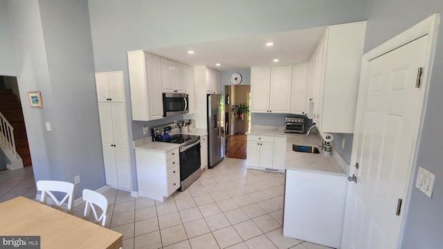 15204 Watergate Rd, Silver Spring, MD 20905 - kitchen with appliances with stainless steel finishes, a sink, light tile patterned floors, white cabinetry, and recessed lighting