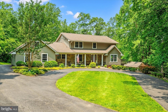 8112 Vista Point Ln, Fairfax Station, VA 22039 - traditional-style house featuring asphalt driveway, stone siding, covered porch, a front lawn, and roof with shingles