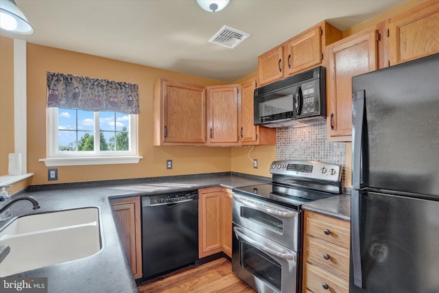 2325 Slater Hill Ln E Unit 39, York, PA 17406 - kitchen with black appliances, a sink, light wood finished floors, tasteful backsplash, and dark countertops