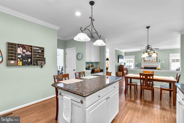 1412 Eagle Ridge Run, Bel Air, MD 21014 - kitchen featuring crown molding, white cabinets, light wood-style flooring, and a fireplace