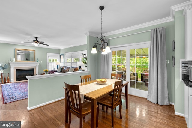 1412 Eagle Ridge Run, Bel Air, MD 21014 - dining area with a glass covered fireplace, ornamental molding, wood finished floors, a ceiling fan, and baseboards
