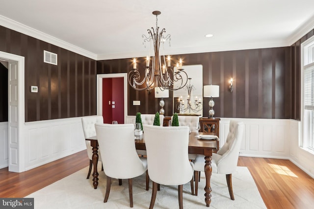 2 Autumn Meadow Ln, Malvern, PA 19355 - dining area featuring wood finished floors, a chandelier, a decorative wall, ornamental molding, and wainscoting