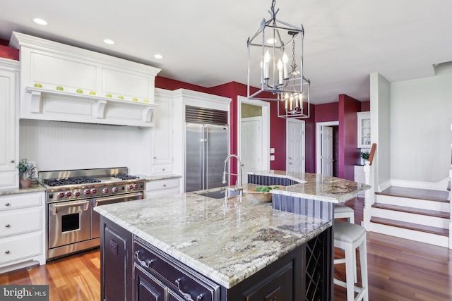 2 Autumn Meadow Ln, Malvern, PA 19355 - kitchen with high quality appliances, a sink, white cabinetry, light wood finished floors, and recessed lighting
