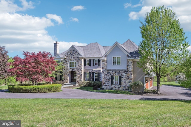 2 Autumn Meadow Ln, Malvern, PA 19355 - view of front facade featuring stone siding, a front lawn, and a chimney