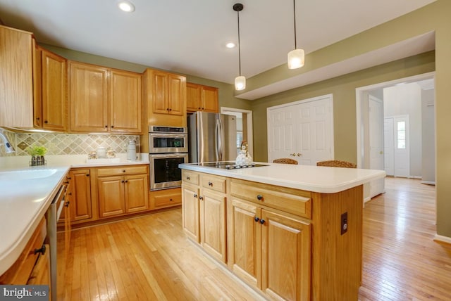 20479 Quarterpath Trace Cir, Sterling, VA 20165 - kitchen with light wood-style floors, stainless steel appliances, a kitchen island, a sink, and decorative backsplash