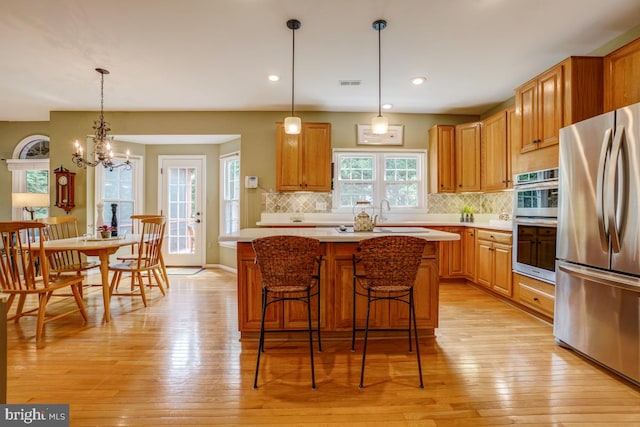 20479 Quarterpath Trace Cir, Sterling, VA 20165 - kitchen featuring stainless steel appliances, light countertops, tasteful backsplash, light wood-type flooring, and recessed lighting