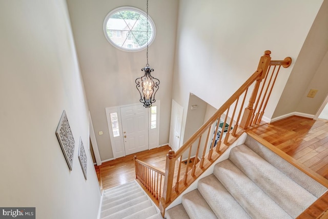 20479 Quarterpath Trace Cir, Sterling, VA 20165 - entrance foyer featuring light wood finished floors, a high ceiling, stairs, a chandelier, and baseboards