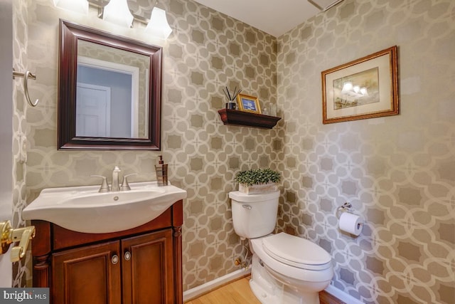 20479 Quarterpath Trace Cir, Sterling, VA 20165 - bathroom featuring wallpapered walls, toilet, wood finished floors, vanity, and baseboards