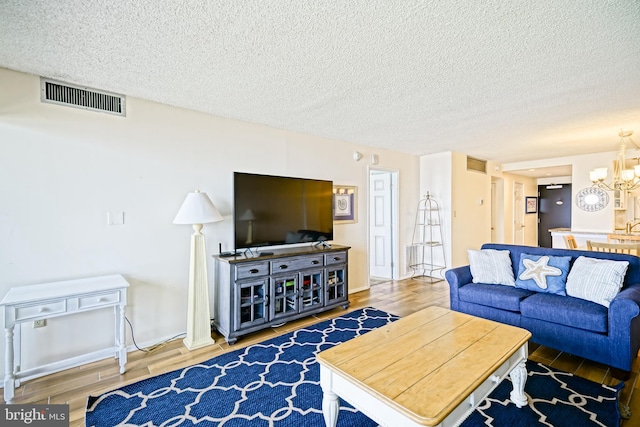 604 Dover House Rd Unit 604S, Bethany Beach, DE 19930 - living room featuring wood finished floors, a chandelier, a textured ceiling, and baseboards