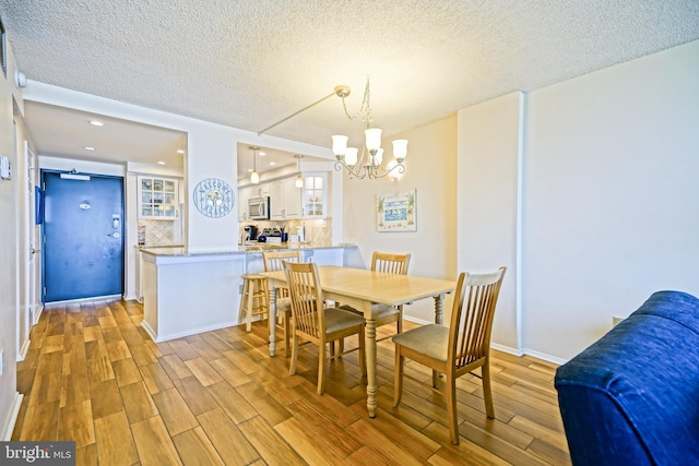 604 Dover House Rd Unit 604S, Bethany Beach, DE 19930 - dining space featuring light wood-style floors, a chandelier, a textured ceiling, and recessed lighting