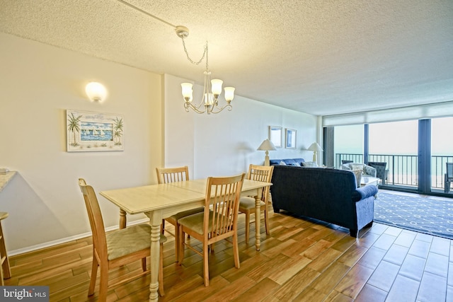 604 Dover House Rd Unit 604S, Bethany Beach, DE 19930 - dining space featuring wood finished floors, a chandelier, a textured ceiling, and expansive windows