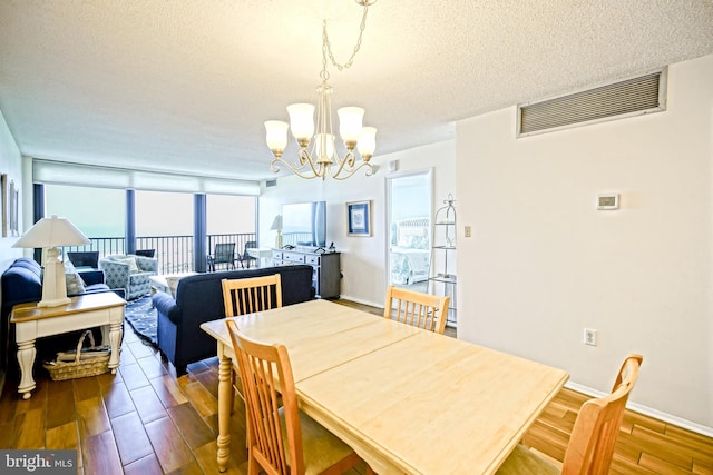 604 Dover House Rd Unit 604S, Bethany Beach, DE 19930 - dining area featuring a chandelier, wood finished floors, a textured ceiling, and baseboards