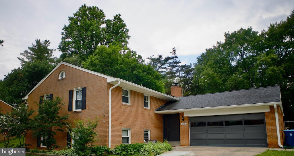 5116 Portsmouth Rd, Fairfax, VA 22032 - view of front of property featuring an attached garage, brick siding, concrete driveway, and a chimney