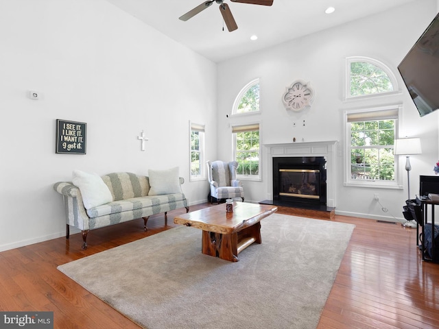 5185 Turkey Point Road, North East, MD 21901 - living area with plenty of natural light, a ceiling fan, a high ceiling, hardwood / wood-style flooring, and a glass covered fireplace
