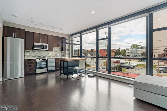 1320 Fenwick Ln Unit 201, Silver Spring, MD 20910 - kitchen featuring stainless steel appliances, floor to ceiling windows, dark brown cabinets, dark wood finished floors, and tasteful backsplash