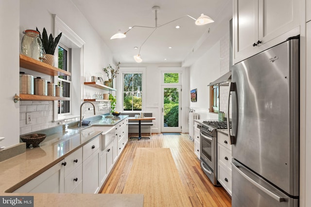 111 8th St SE, Washington, DC 20003 - kitchen with appliances with stainless steel finishes, light wood-style flooring, a sink, white cabinetry, and open shelves