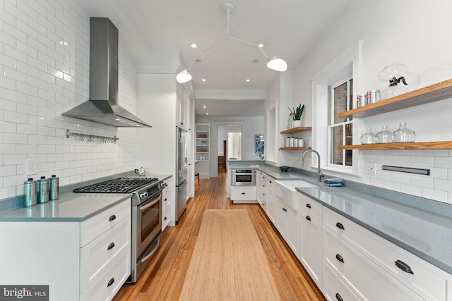 111 8th St SE, Washington, DC 20003 - kitchen with wall chimney range hood, appliances with stainless steel finishes, a sink, open shelves, and white cabinetry