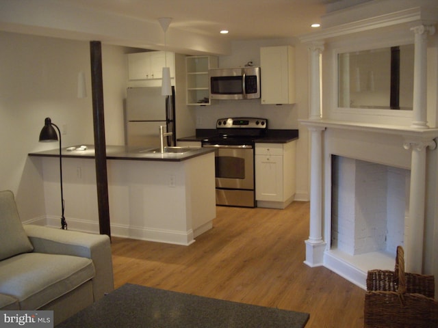 111 8th St SE, Washington, DC 20003 - kitchen featuring appliances with stainless steel finishes, dark countertops, white cabinets, a sink, and recessed lighting