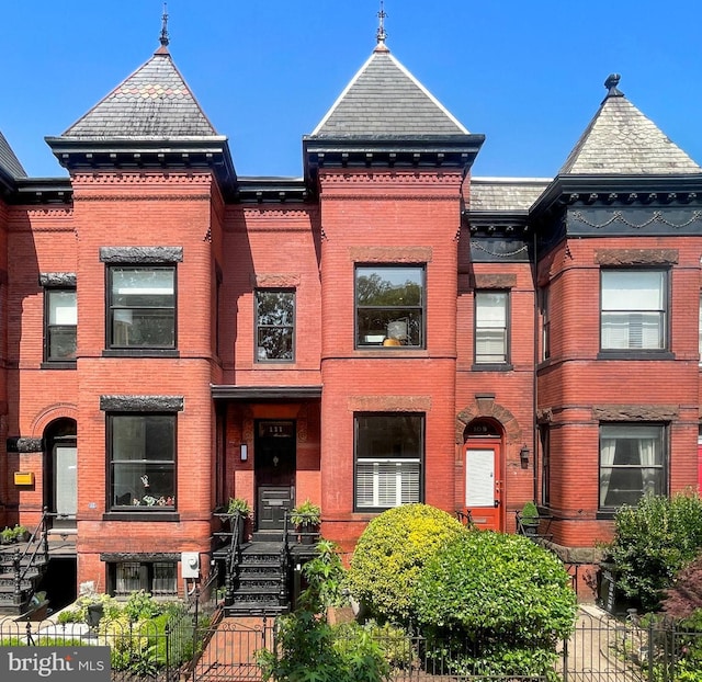 111 8th St SE, Washington, DC 20003 - view of front of house featuring brick siding, a high end roof, and a fenced front yard