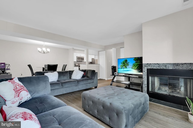 1601 Carriage House Ter Unit D, Silver Spring, MD 20904 - living room featuring light wood finished floors, a chandelier, and a high end fireplace