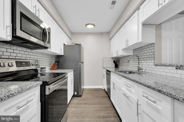 1601 Carriage House Ter Unit D, Silver Spring, MD 20904 - kitchen with stainless steel appliances, a sink, white cabinetry, and light wood-type flooring