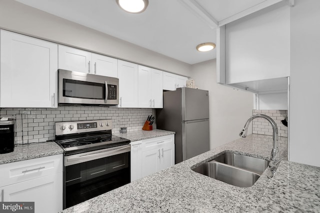 1601 Carriage House Ter Unit D, Silver Spring, MD 20904 - kitchen with appliances with stainless steel finishes, a sink, tasteful backsplash, light stone counters, and white cabinetry