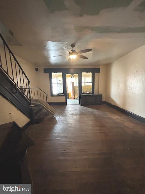 5328 Willows Ave, Philadelphia, PA 19143 - unfurnished living room featuring ceiling fan, baseboards, wood-type flooring, and stairway