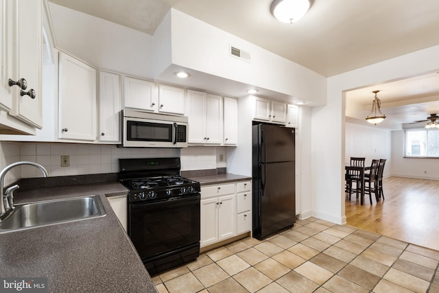 3305 Fleet St, Baltimore, MD 21224 - kitchen with black appliances, a sink, dark countertops, and white cabinetry