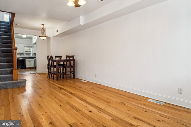 3305 Fleet St, Baltimore, MD 21224 - dining area with light wood-style flooring, stairs, and baseboards