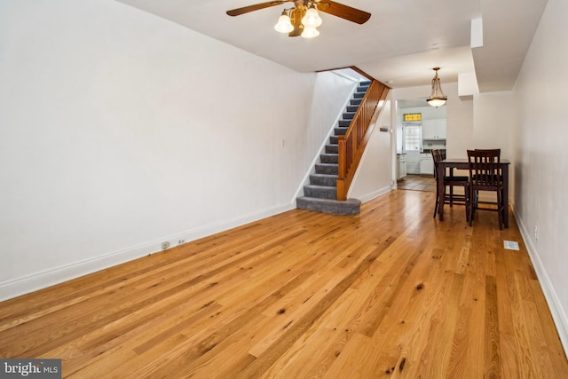 3305 Fleet St, Baltimore, MD 21224 - living room featuring stairway, a ceiling fan, light wood-type flooring, and baseboards
