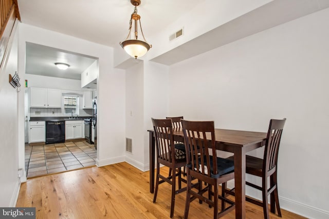 3305 Fleet St, Baltimore, MD 21224 - dining area featuring light wood-style flooring and baseboards