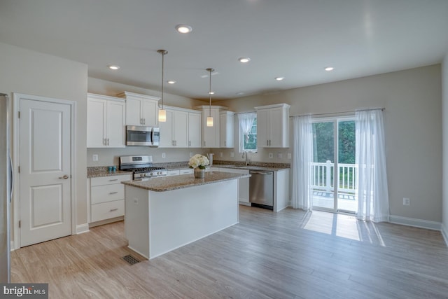 35141 Wright Way, Millsboro, DE 19966 - kitchen featuring appliances with stainless steel finishes, white cabinets, a sink, light wood-type flooring, and recessed lighting
